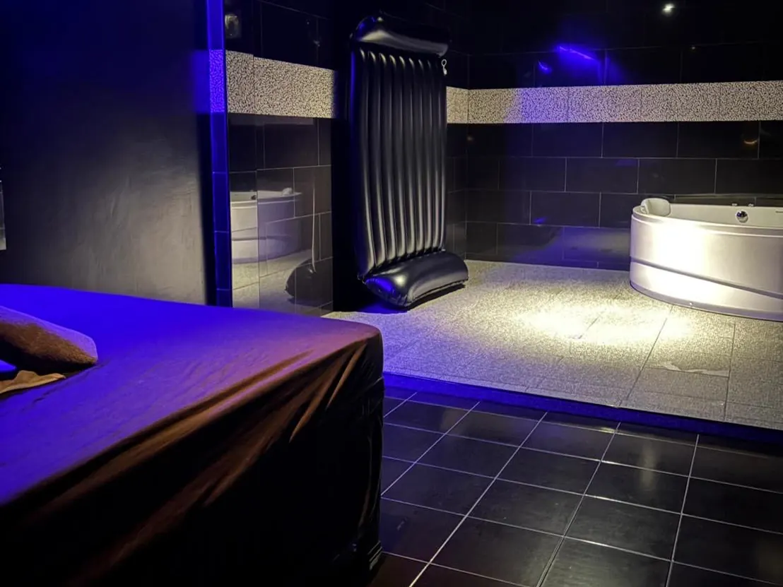 A jacuzzi room at 666 Class on Sukhumvit Soi 33, Bangkok: massage bed, nuru mattress and corner tub in blue light