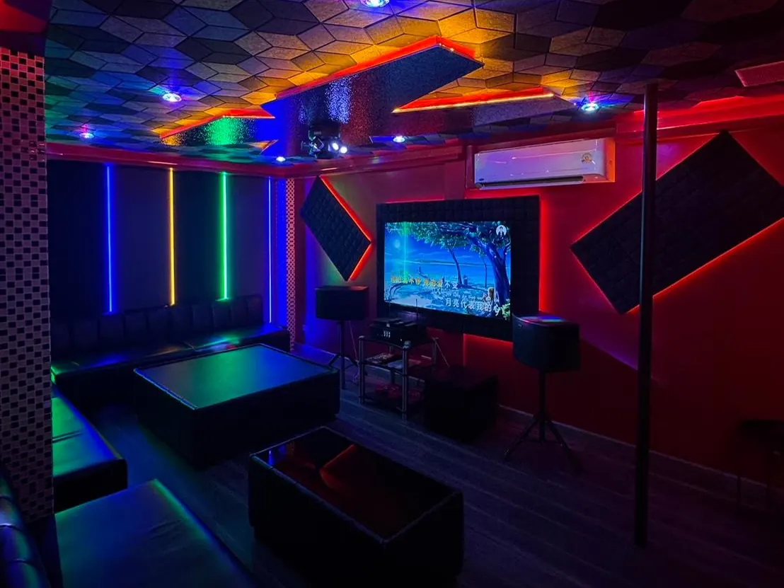 A private KTV karaoke room at Drake Luxury Lounge on Sukhumvit Soi 33, Bangkok: sofas, screen and speakers under coloured lights