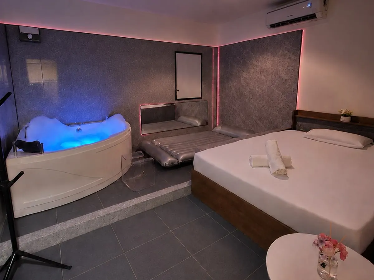 A jacuzzi room at Miki Nuru on Sukhumvit Soi 22, Bangkok: corner tub, a separate silver nuru mattress and a made-up bed