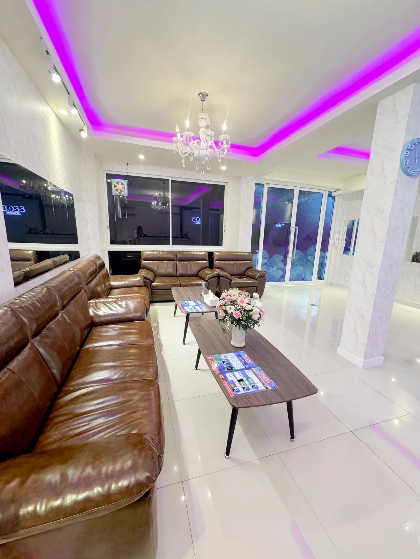 Lounge at Boss Massage 33 with leather sofas under a purple-lit ceiling