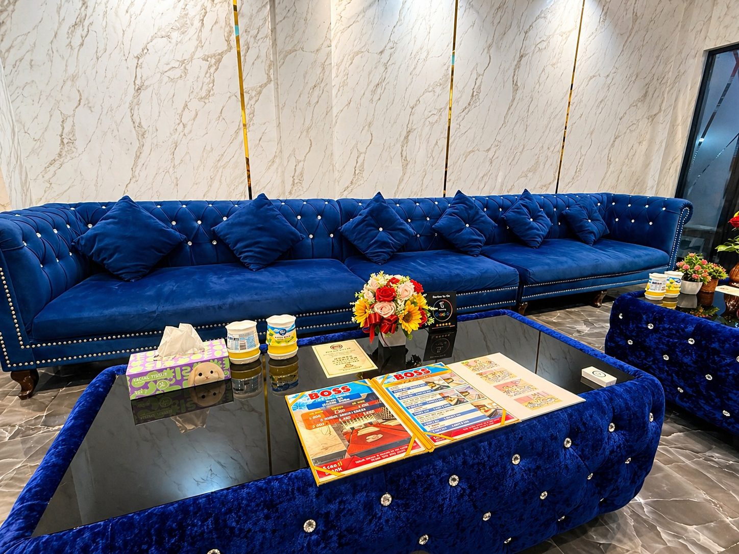 Lounge sofas and price menus on the table at Boss Massage