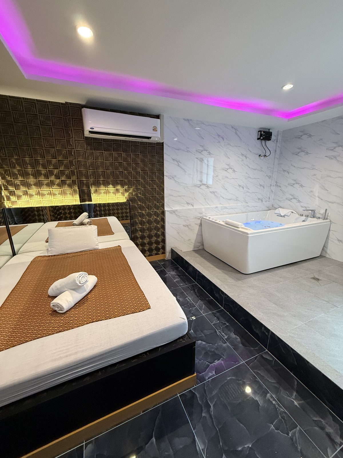 Second VIP jacuzzi room: massage bed and a jacuzzi on a marble platform