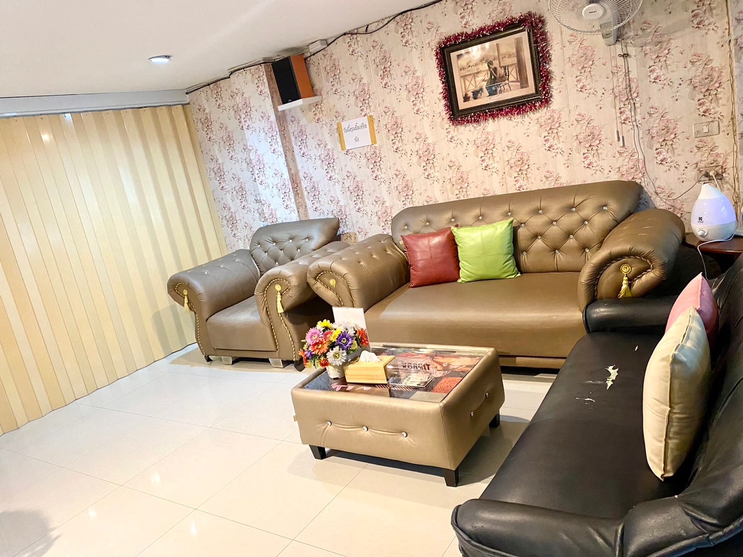 Waiting lounge at Princess Spa with leather sofas and floral wallpaper